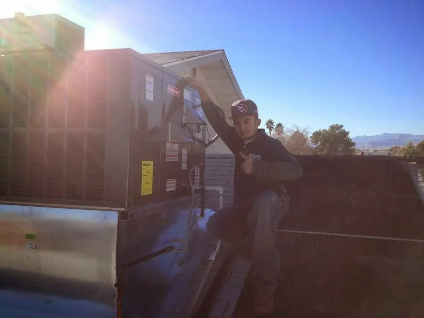 HVAC technician performing Air Duct Cleaning on a rooftop unit in Chillum